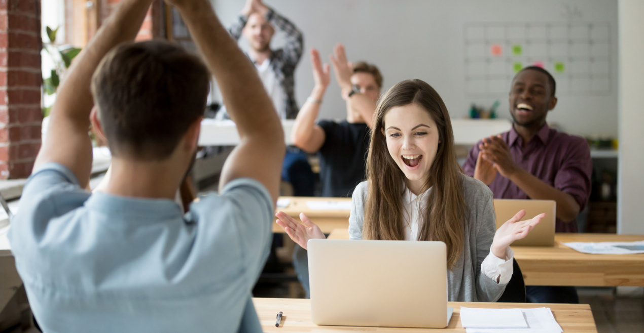 girl being applauded for succeding at work - how to retain workers - open office with young people - frezza magazine